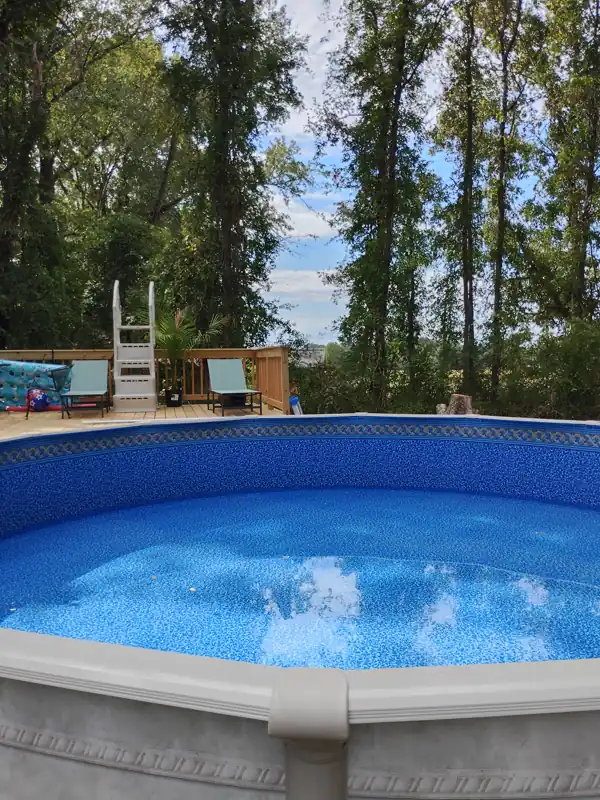 Above-ground pool with a new liner next to a deck and ladder
